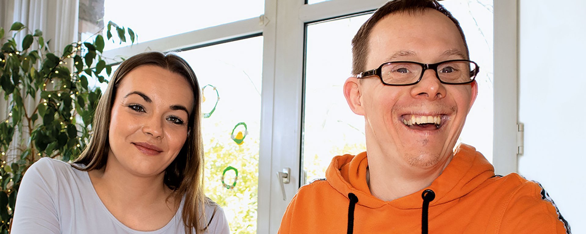 Eine Junge Frau malt mit einem Mann ein Bild mit bunten Farben